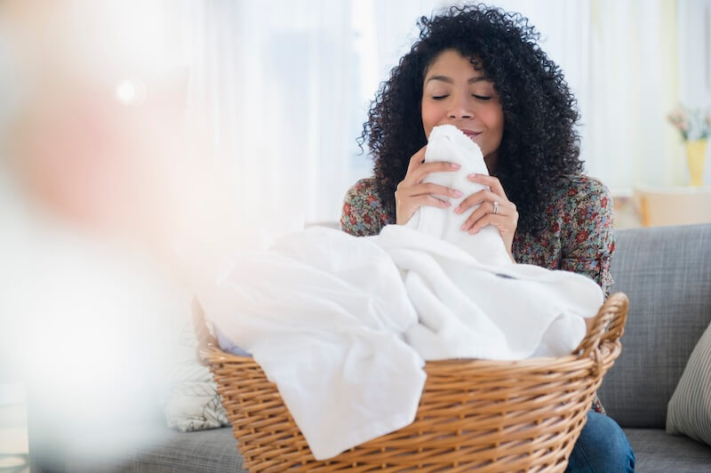 A woman smelling clean laundry.